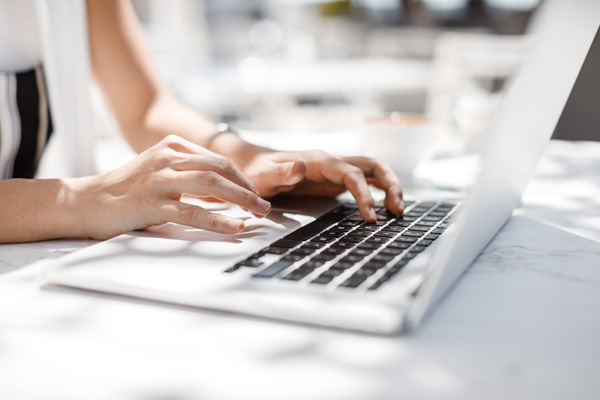 Woman using white laptop to buy cam site