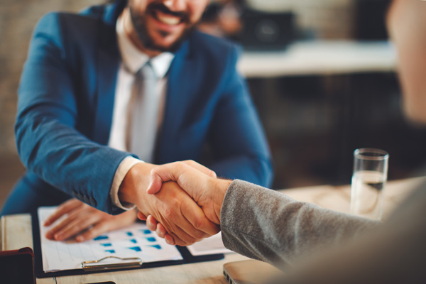 Bearded adult site broker shaking hands with client
