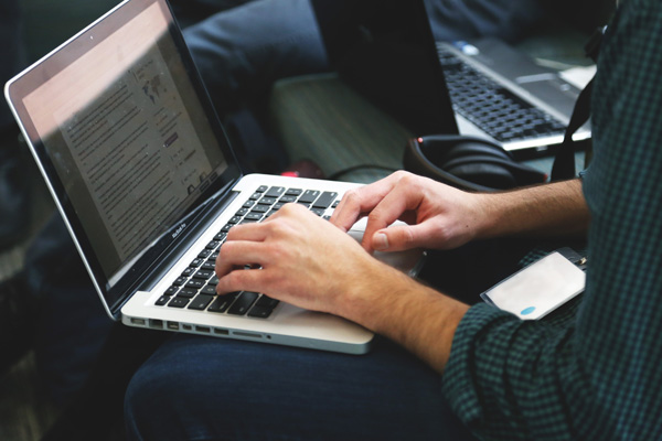 Man browsing membership sites on laptop
