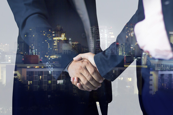 Reflection of adult industry professionals shaking hands in window