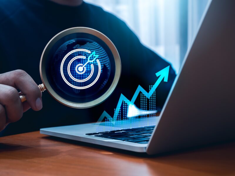 A graph, a laptop and a magnifying glass.