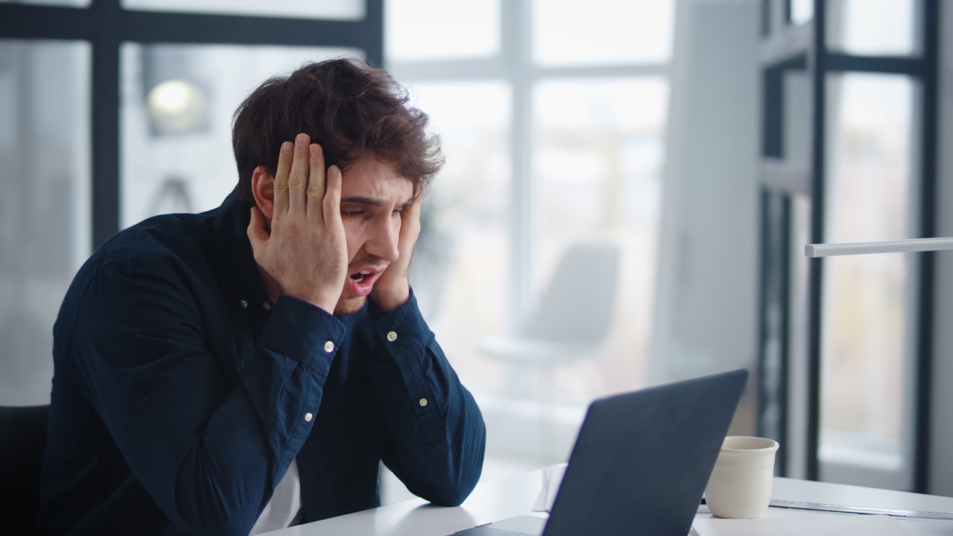 An upset man looking at computer